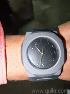 Aura Branded Watch That Features a Matte Black Finish And a Dial With Arabic Numerals.